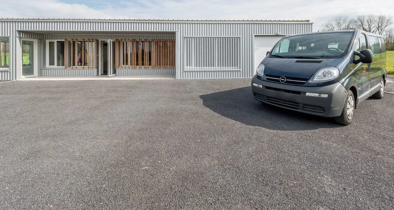 Fourgon funéraire stationné sur la cour extérieure devant le bâtiment de l'agence.